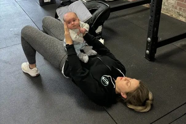 Red Eye CrossFit Mom Holding a Baby